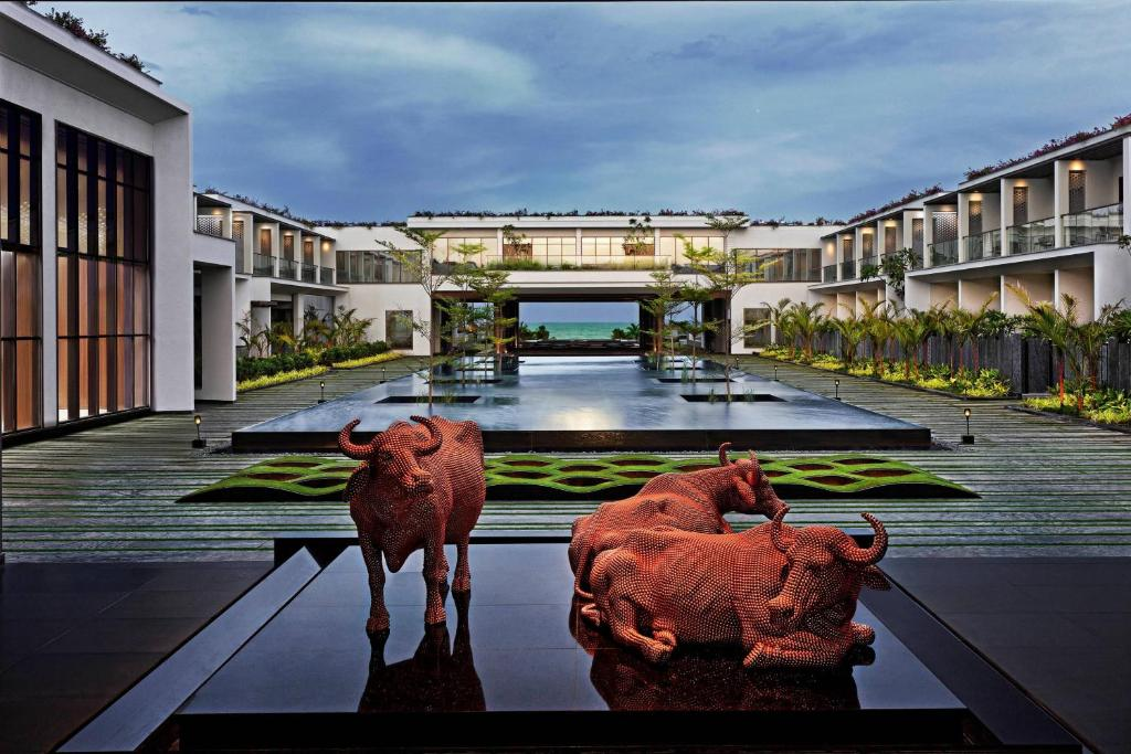 Resort courtyard with a reflecting pool, landscaped gardens and sculptural bulls